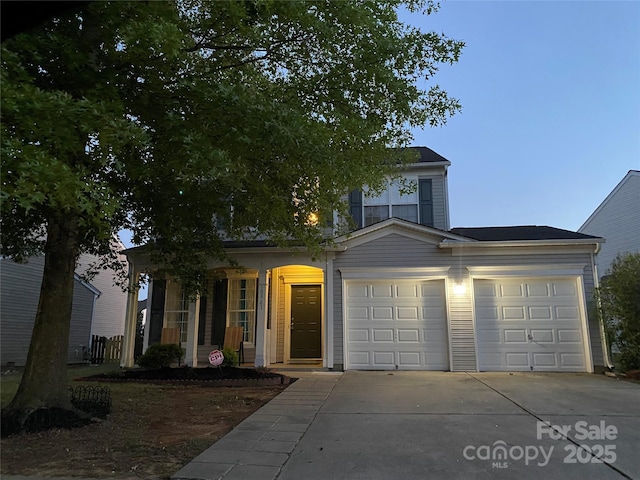 view of front of house featuring concrete driveway, a porch, and a garage