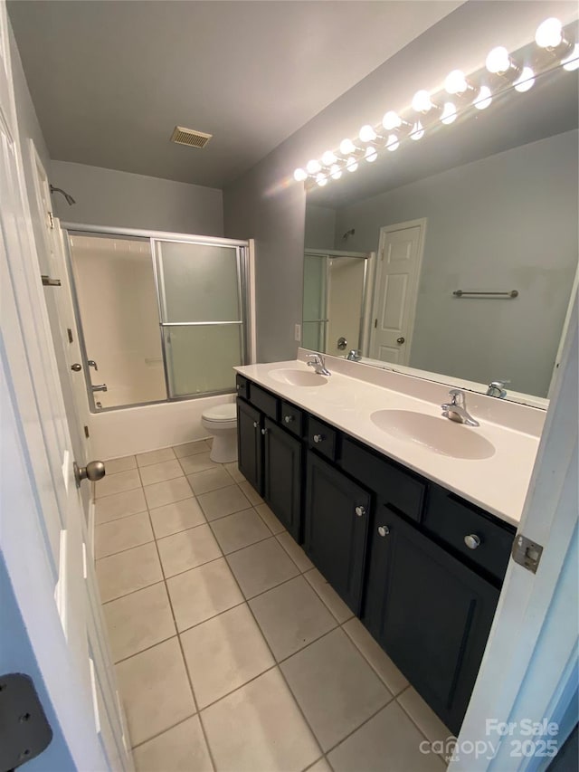 bathroom with a sink, tile patterned flooring, double vanity, and visible vents