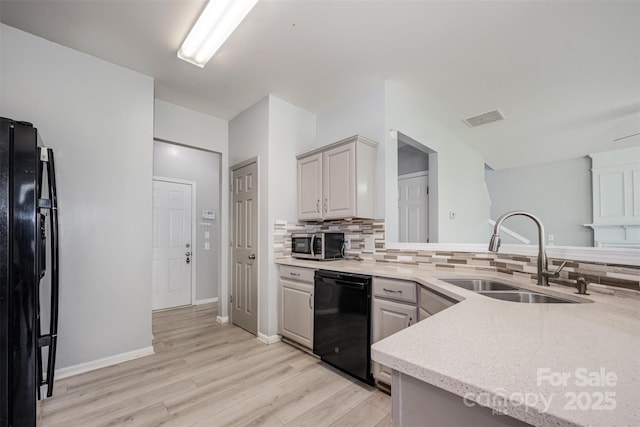 10901 Claude Freeman Dr, Charlotte, NC 28262 - kitchen with black appliances, light wood-style flooring, and backsplash