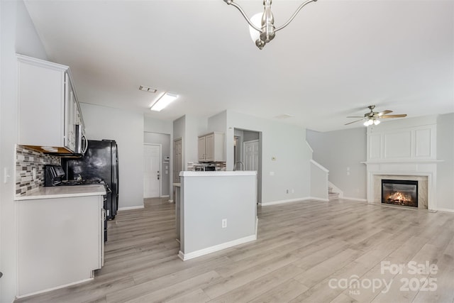 10901 Claude Freeman Dr, Charlotte, NC 28262 - kitchen with backsplash, stainless steel microwave, light wood finished floors, light countertops, and ceiling fan
