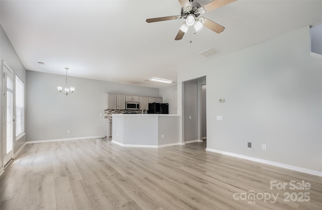 10901 Claude Freeman Dr, Charlotte, NC 28262 - unfurnished living room featuring a chandelier, light wood-style floors, and a ceiling fan
