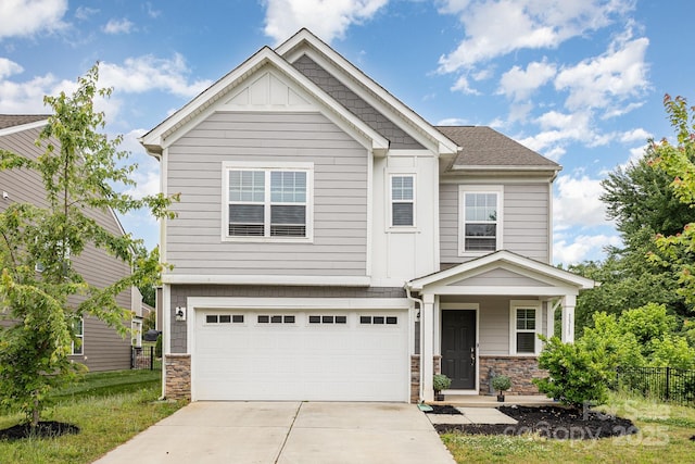 craftsman inspired home featuring driveway, an attached garage, stone siding, fence, and board and batten siding