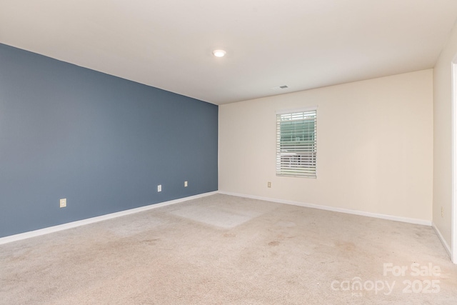 spare room with light colored carpet, baseboards, and recessed lighting