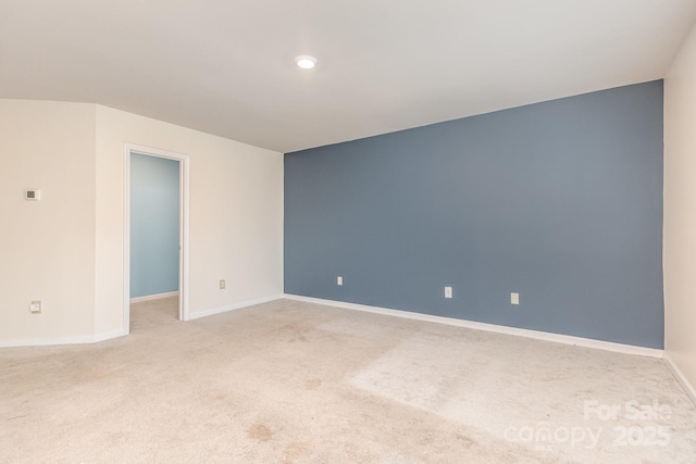 spare room with light colored carpet and baseboards