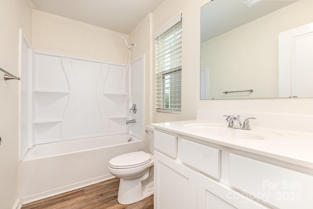 bathroom featuring toilet, wood finished floors, shower / tub combination, and vanity