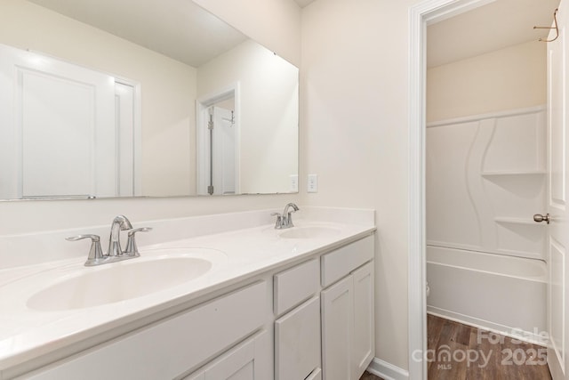 bathroom with wood finished floors and double vanity