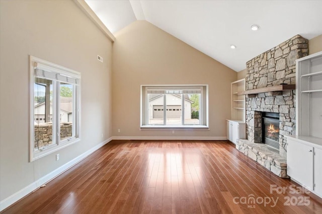 452 Kyfields, Weaverville, NC 28787 - unfurnished living room featuring a stone fireplace, wood finished floors, high vaulted ceiling, and baseboards