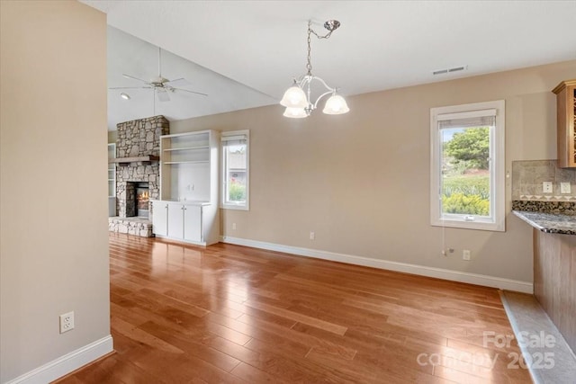 452 Kyfields, Weaverville, NC 28787 - unfurnished dining area featuring wood finished floors, baseboards, a chandelier, a ceiling fan, and lofted ceiling