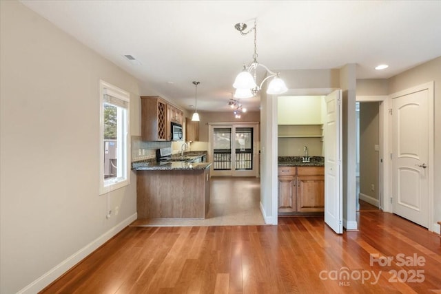 452 Kyfields, Weaverville, NC 28787 - kitchen featuring baseboards, stainless steel microwave, wood finished floors, a sink, and decorative light fixtures