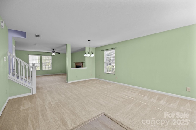 unfurnished living room with light carpet, ceiling fan, and baseboards