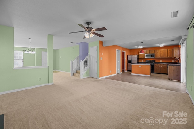 unfurnished living room featuring light colored carpet, baseboards, and a chandelier
