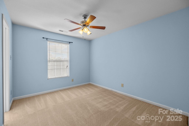 carpeted empty room with a ceiling fan and baseboards