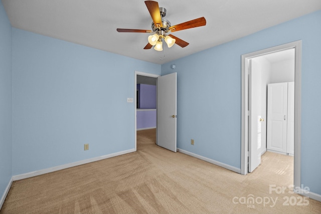 unfurnished bedroom with carpet floors, baseboards, and a ceiling fan
