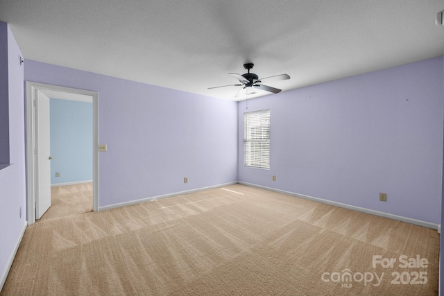 empty room with carpet flooring, ceiling fan, and baseboards