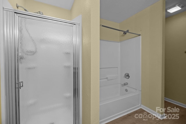 full bathroom with wood finished floors and baseboards