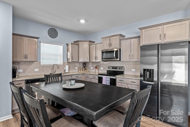 kitchen featuring light stone countertops, stainless steel appliances, and backsplash