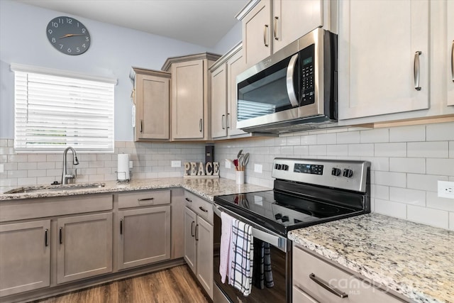 kitchen with backsplash, dark wood-style floors, appliances with stainless steel finishes, and a sink