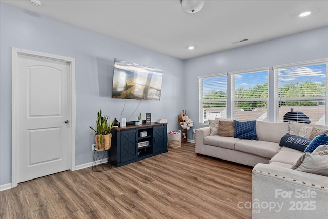 living area with baseboards, recessed lighting, visible vents, and wood finished floors
