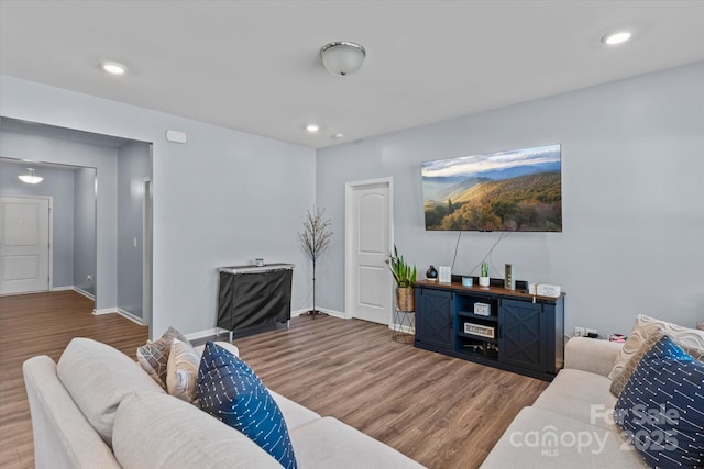 living room with wood finished floors, baseboards, and recessed lighting