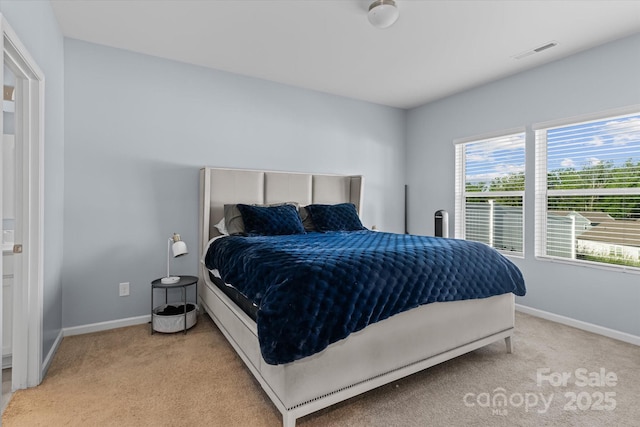 bedroom with baseboards, visible vents, and light colored carpet