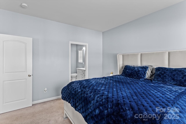 bedroom with baseboards, ensuite bath, and carpet floors