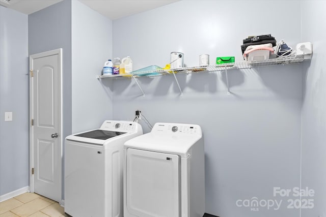 laundry room featuring separate washer and dryer, laundry area, and light tile patterned flooring