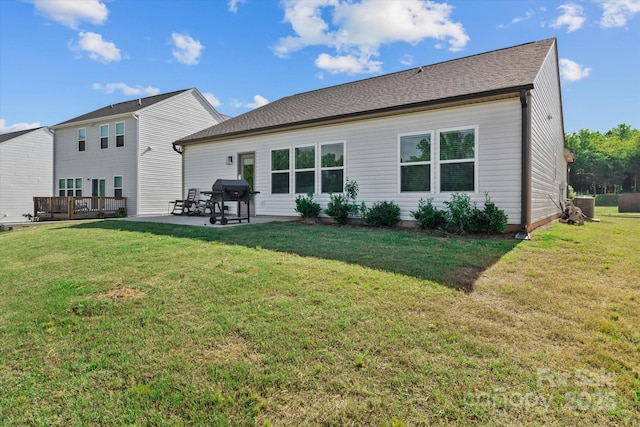 rear view of property with a patio area, a deck, a lawn, and central AC