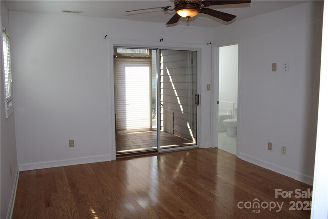 unfurnished room with ceiling fan, wood finished floors, and baseboards