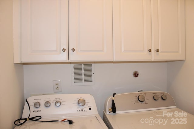 clothes washing area featuring independent washer and dryer, visible vents, and cabinet space