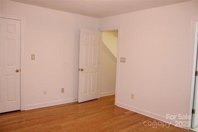 unfurnished bedroom featuring light wood-type flooring and baseboards