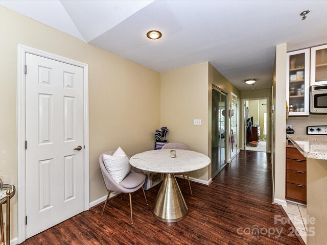 dining space featuring wood finished floors and baseboards