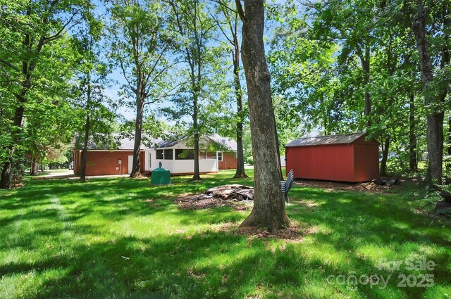 view of grassy yard featuring a shed and an outbuilding