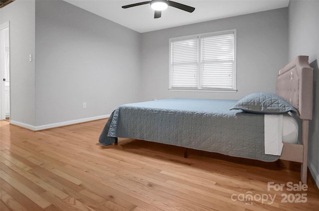 bedroom featuring wood finished floors, baseboards, and a ceiling fan