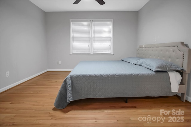 bedroom featuring wood finished floors, baseboards, and ceiling fan