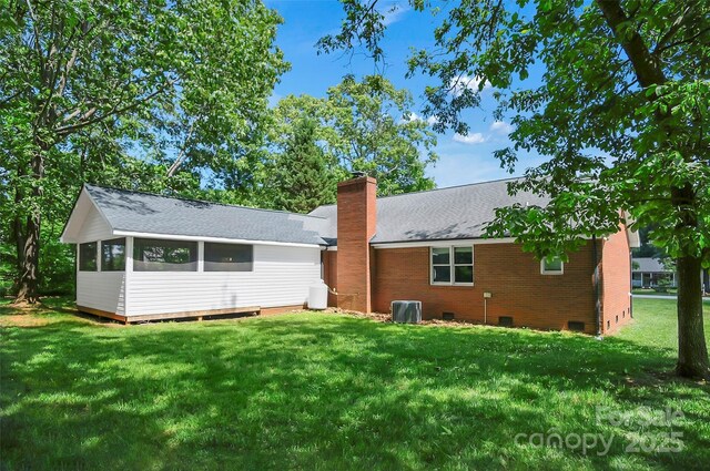 rear view of house with a chimney, crawl space, a lawn, and roof with shingles