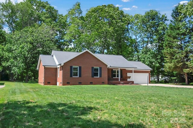 single story home featuring crawl space, an attached garage, driveway, a front lawn, and view of scattered trees