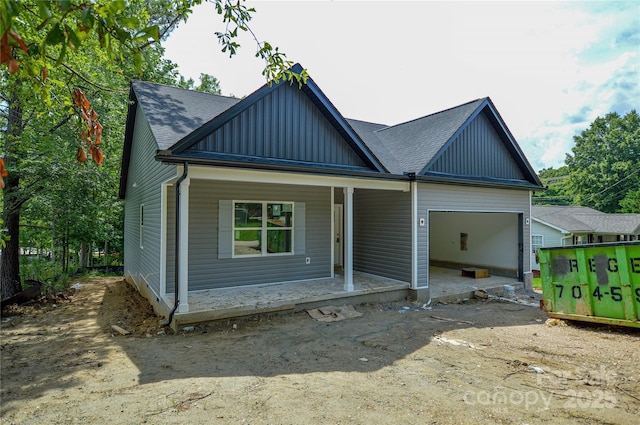 2706 Lyla Ave, Concord, NC 28027 - view of front facade featuring board and batten siding, covered porch, an attached garage, and a shingled roof