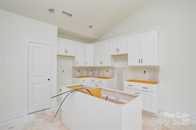 2706 Lyla Ave, Concord, NC 28027 - kitchen featuring vaulted ceiling, white cabinetry, and a kitchen island