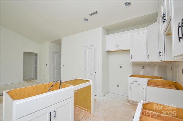 2706 Lyla Ave, Concord, NC 28027 - kitchen featuring white cabinetry, a kitchen island, and vaulted ceiling
