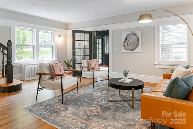 118 Macon Ave, Asheville, NC 28801 - living room with wood finished floors, baseboards, stairway, radiator heating unit, and a textured ceiling