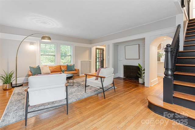 118 Macon Ave, Asheville, NC 28801 - living area with stairs, arched walkways, light wood-type flooring, a fireplace, and baseboards
