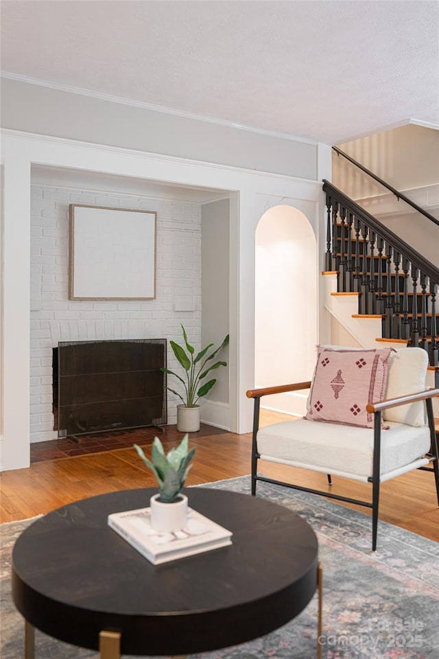 118 Macon Ave, Asheville, NC 28801 - living room with stairway, wood finished floors, crown molding, a fireplace, and arched walkways