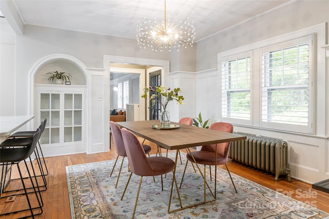 118 Macon Ave, Asheville, NC 28801 - dining space with radiator heating unit, a chandelier, hardwood / wood-style floors, healthy amount of natural light, and crown molding