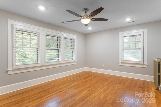118 Macon Ave, Asheville, NC 28801 - spare room featuring light wood-style floors, baseboards, radiator, a ceiling fan, and recessed lighting