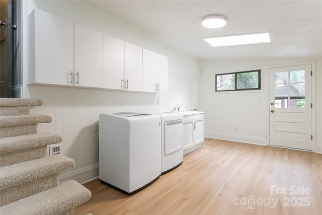 118 Macon Ave, Asheville, NC 28801 - washroom with washing machine and clothes dryer, cabinet space, light wood-style floors, and baseboards