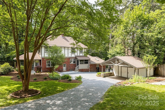 118 Macon Ave, Asheville, NC 28801 - english style home with brick siding, an outdoor structure, roof with shingles, and gravel driveway