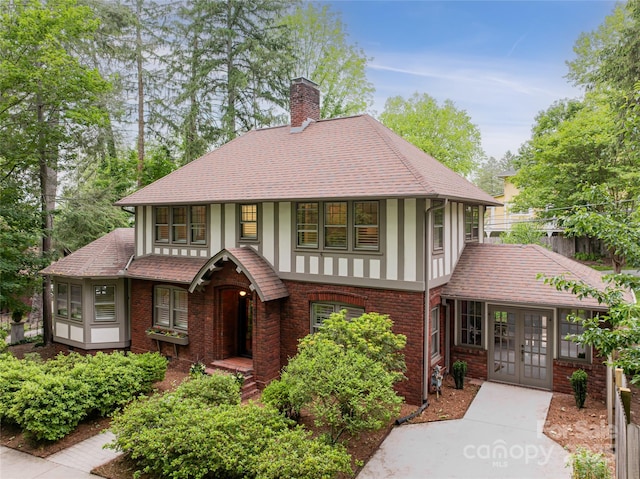 118 Macon Ave, Asheville, NC 28801 - tudor-style house featuring french doors, a chimney, brick siding, and roof with shingles
