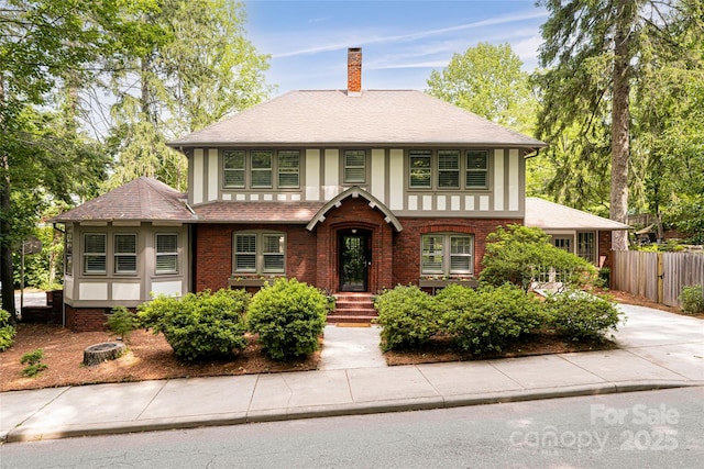 118 Macon Ave, Asheville, NC 28801 - tudor home featuring a chimney, brick siding, and a shingled roof