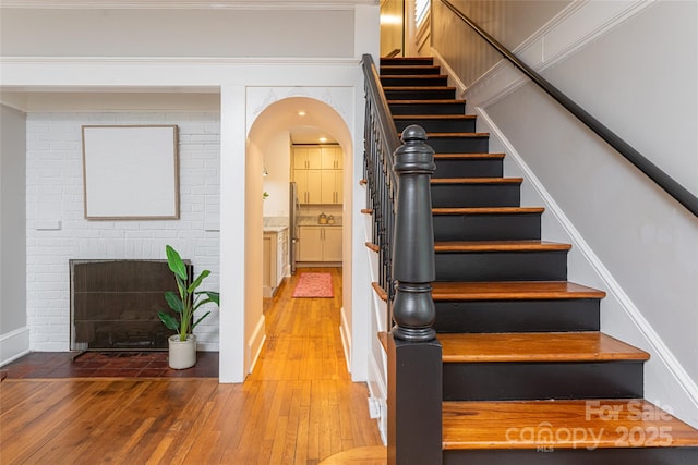 118 Macon Ave, Asheville, NC 28801 - stairs with hardwood / wood-style flooring, a brick fireplace, and arched walkways