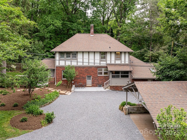118 Macon Ave, Asheville, NC 28801 - view of front facade with a balcony, a chimney, brick siding, stucco siding, and a shingled roof